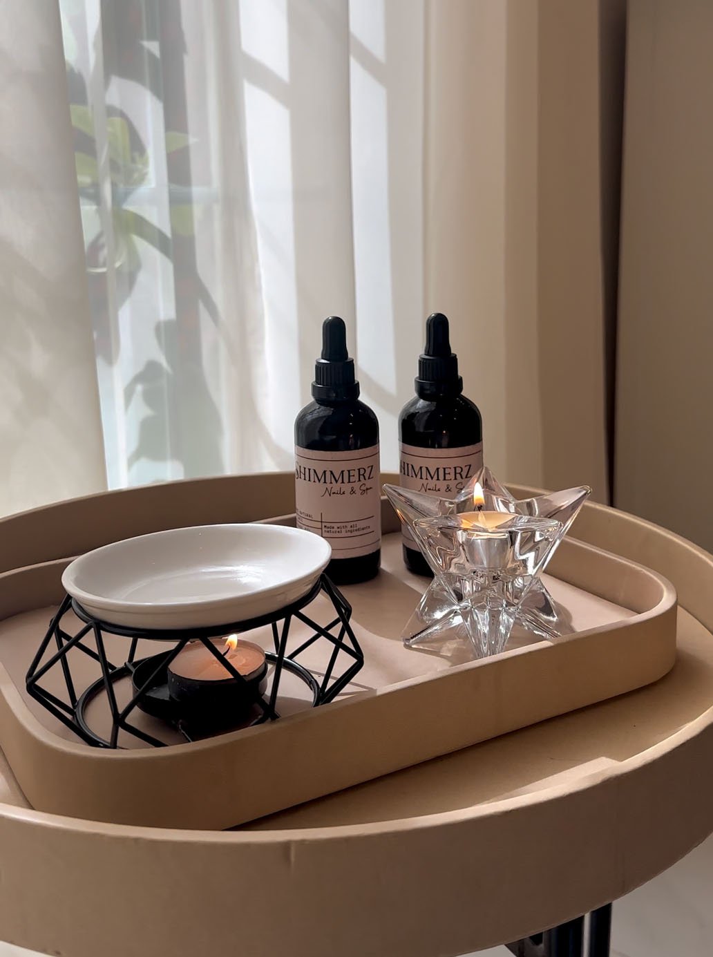 Shimmerz styling tray with oils and a lit candle by a sunlit window